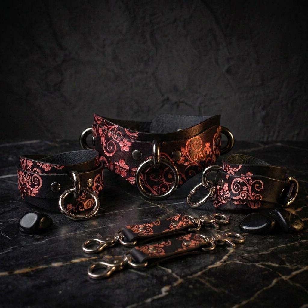 a collection of ornate leather straps and buckles, featuring intricate floral and scroll designs, arranged on a dark surface.