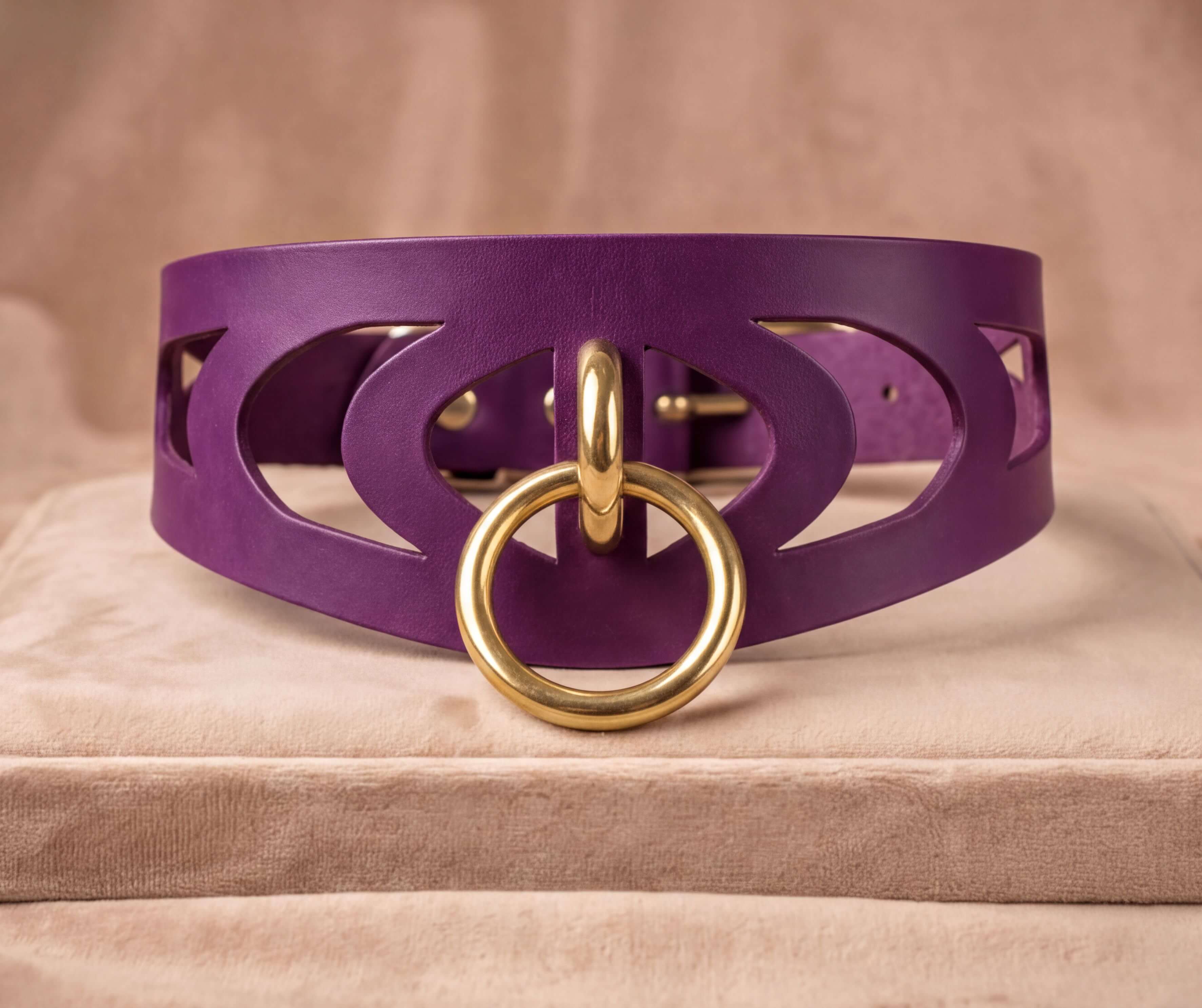 A purple leather choker necklace with a gold ring and a cutout design on the front.