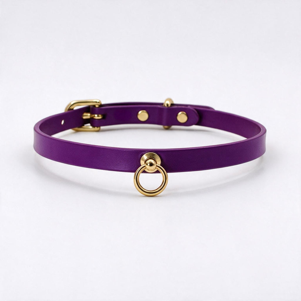 A purple leather choker collar with a gold ring and buckle.