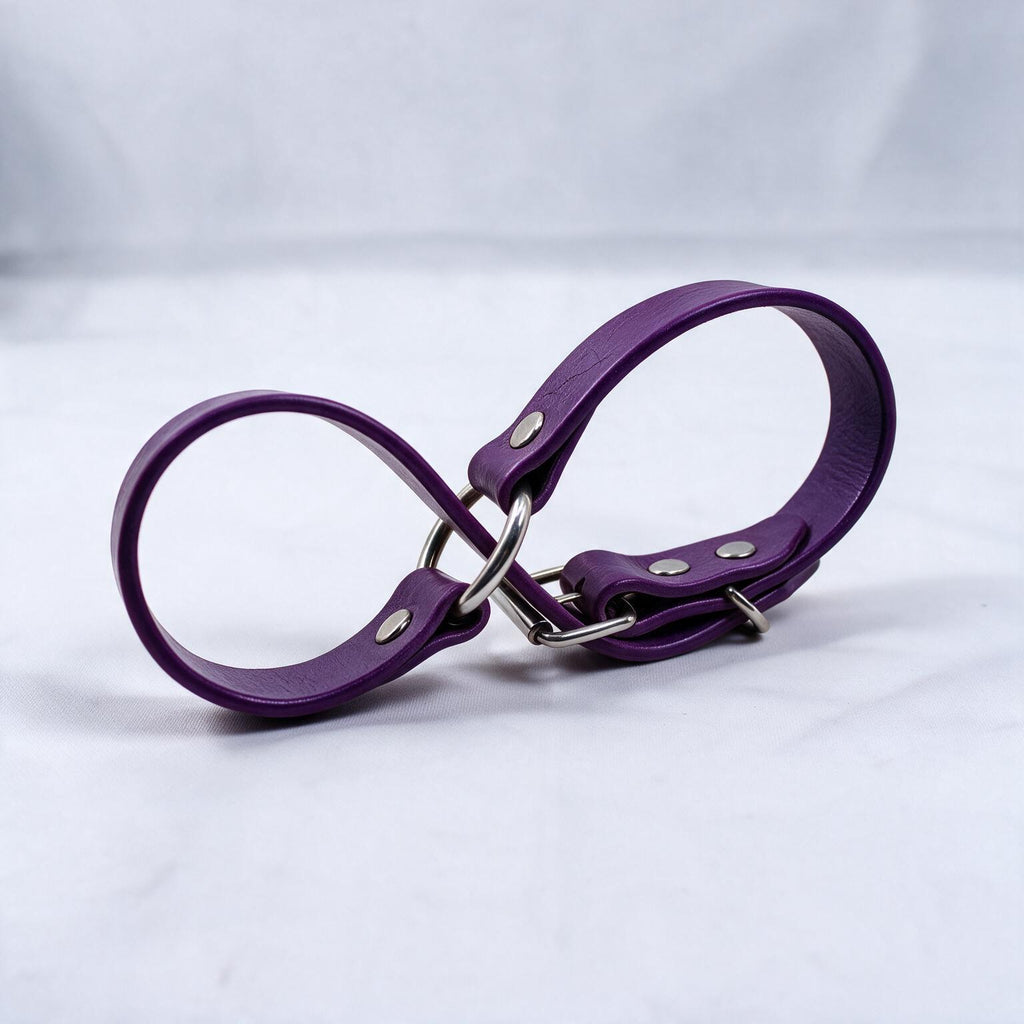 A purple leather strap with metal buckles and clips is shown against a white background.