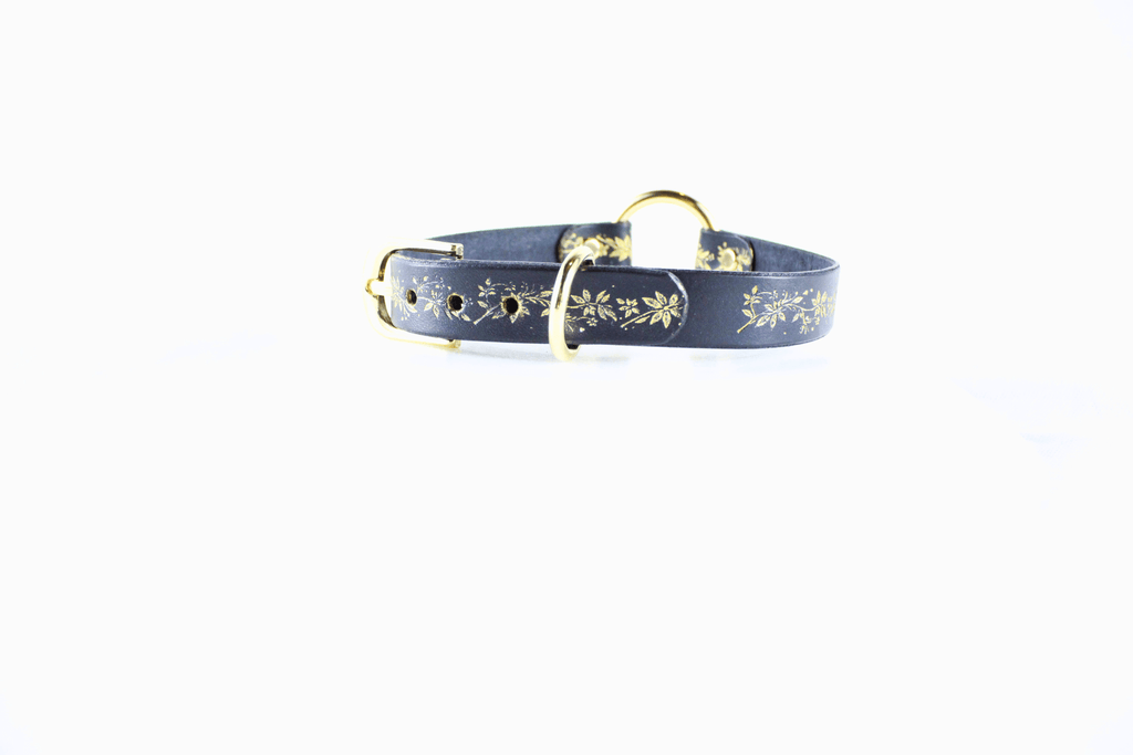 Black Leather Fetish Collar with golden floral pattern and polished O-ring for bondage and submissive jewelry.
