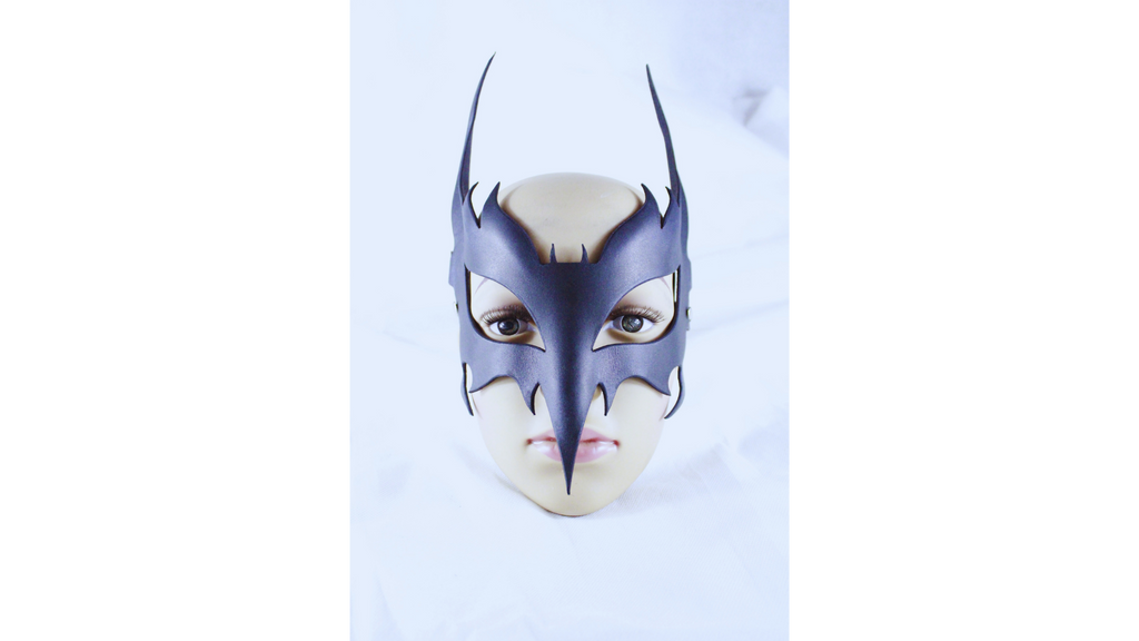 A mannequin head wearing a black mask with sharp teeth and a pointed nose, resembling a mask or costume.