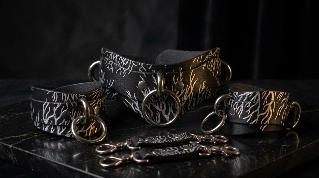 A collection of leather straps and buckles with a zebra print pattern, displayed on a black surface against a dark background.