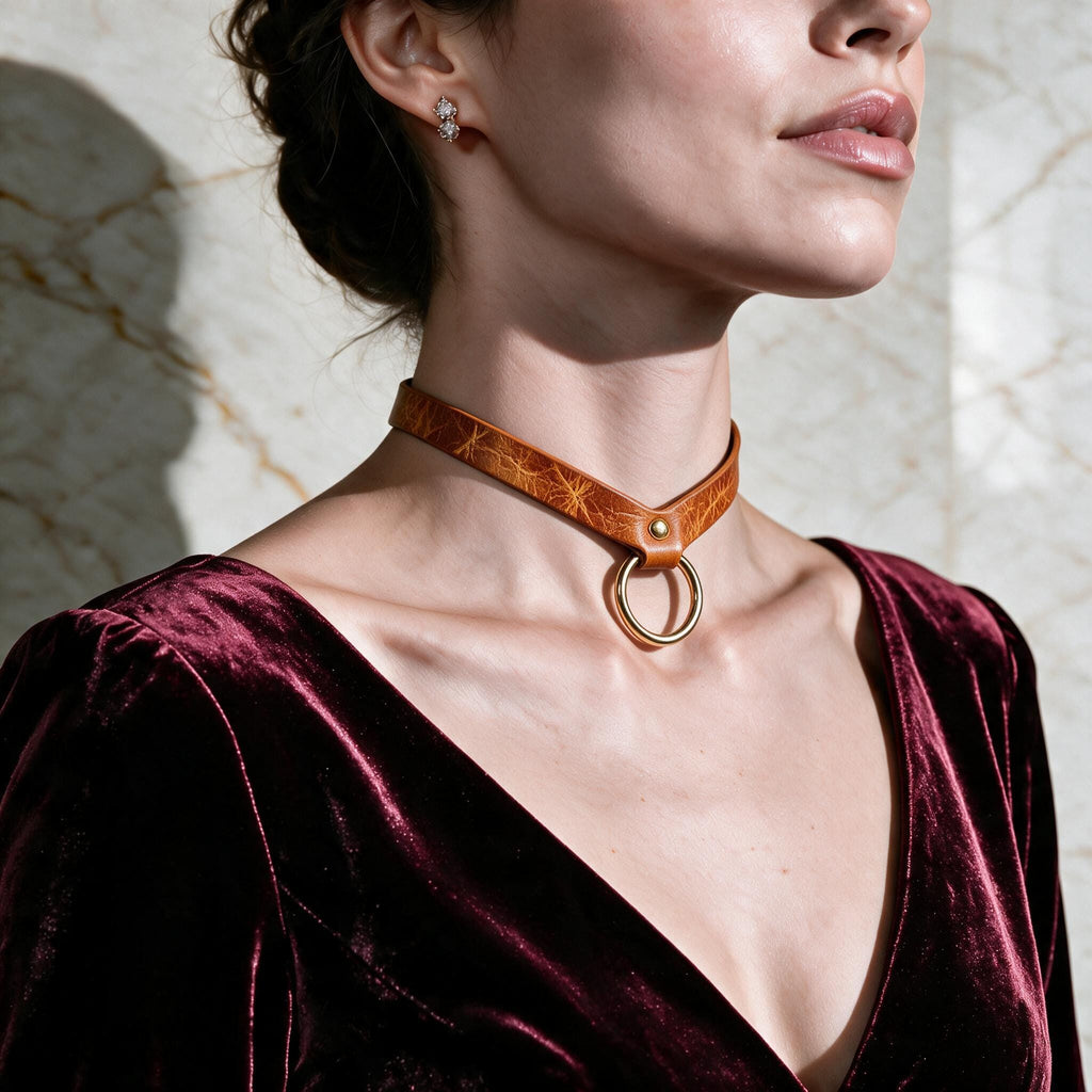 A woman wearing a burgundy velvet dress with a gold-colored choker necklace and earrings.