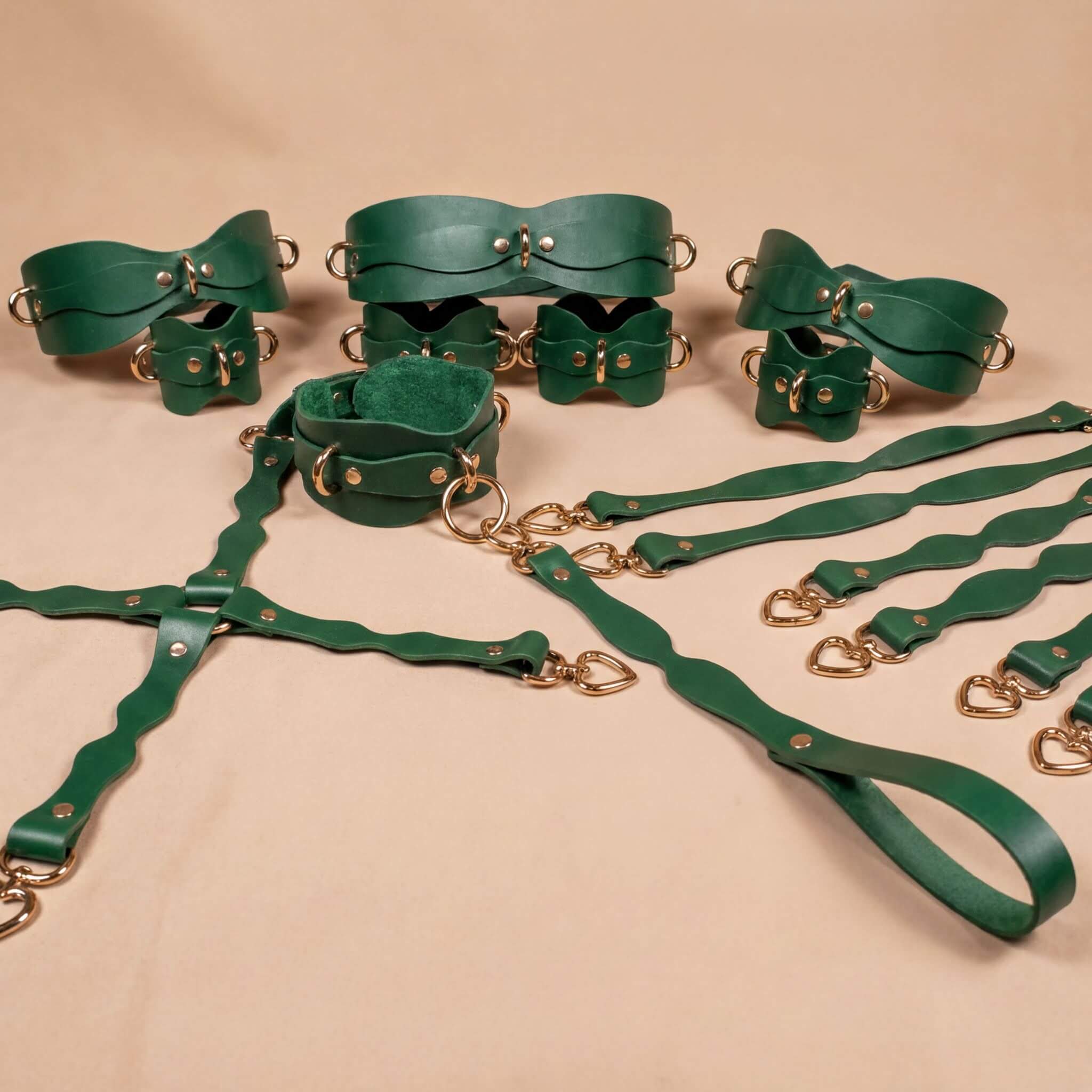 a collection of green leather straps and buckles arranged on a beige background.