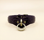 A purple leather choker collar with a gold ring and buckle.