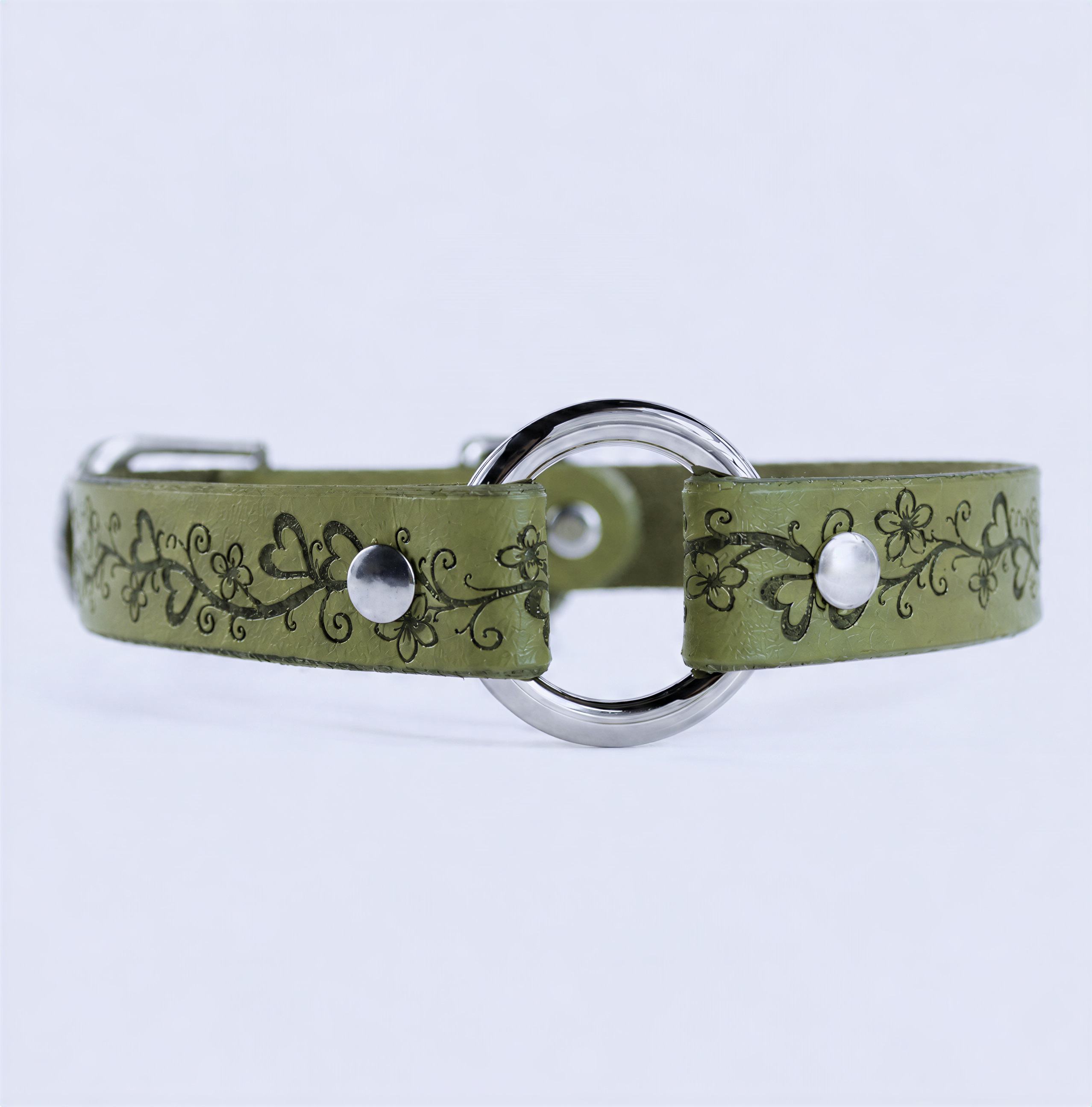 A green leather collar with a floral design and metal ring.