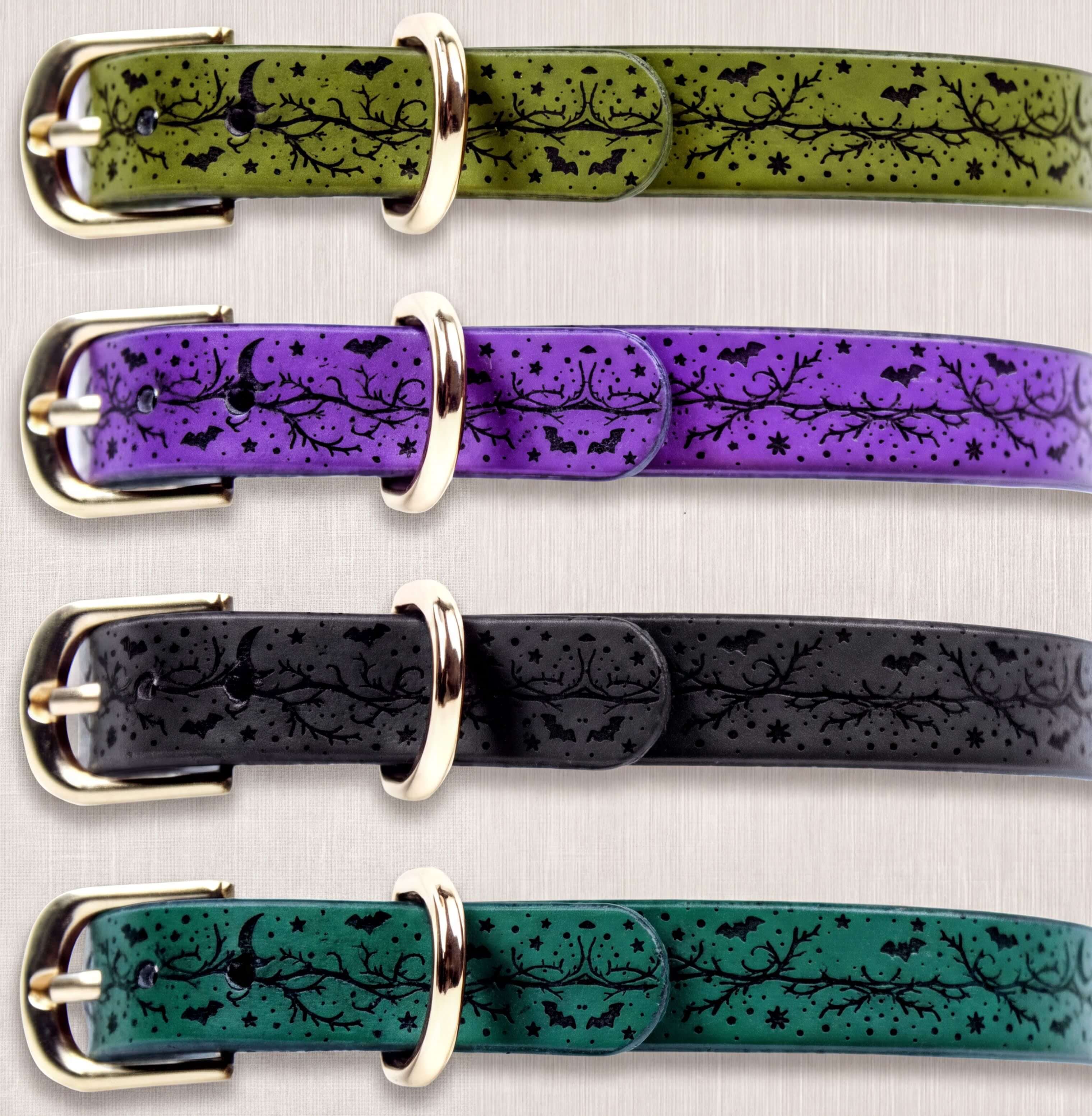a collection of four colorful leather belts with unique designs. The belts are arranged in a row, showcasing their distinct patterns and colors.