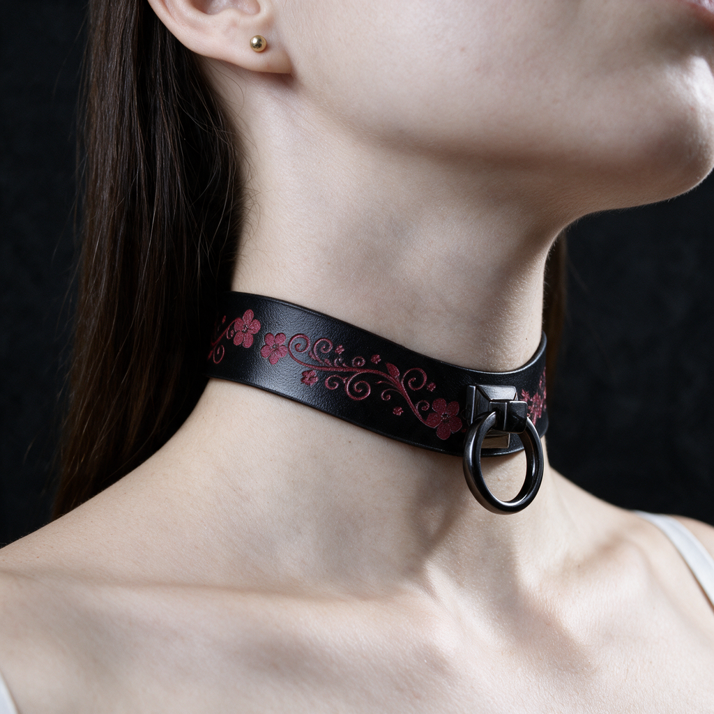 A close-up of a woman's neck and chin wearing a black choker necklace with a floral design.