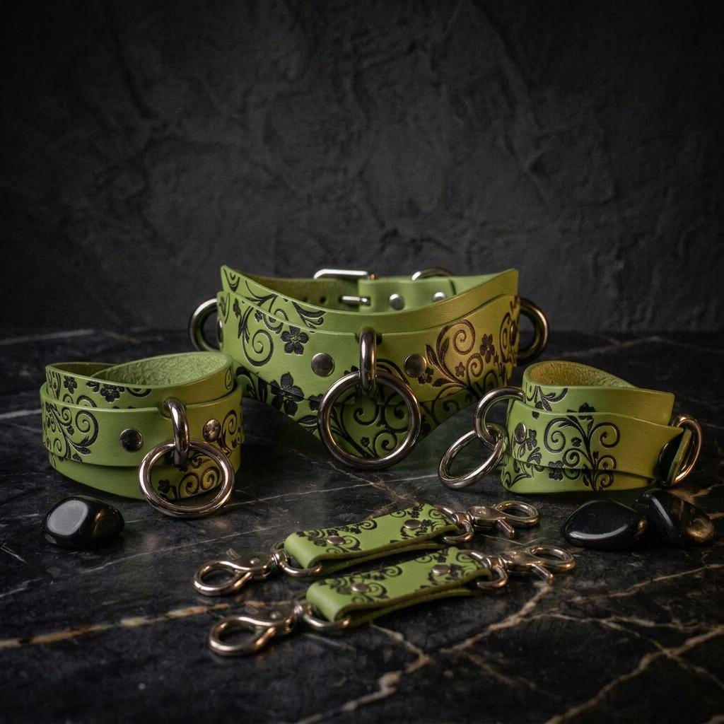 a collection of green leather straps with black floral designs, arranged on a dark surface.