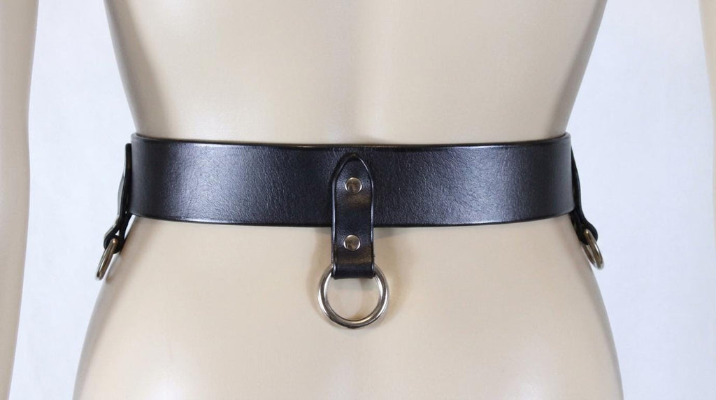 A mannequin wearing a black leather belt with a metal ring and buckle.