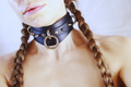 Close-up of a Spiked BDSM Collar made from black leather worn around the neck, showcasing its design and features.