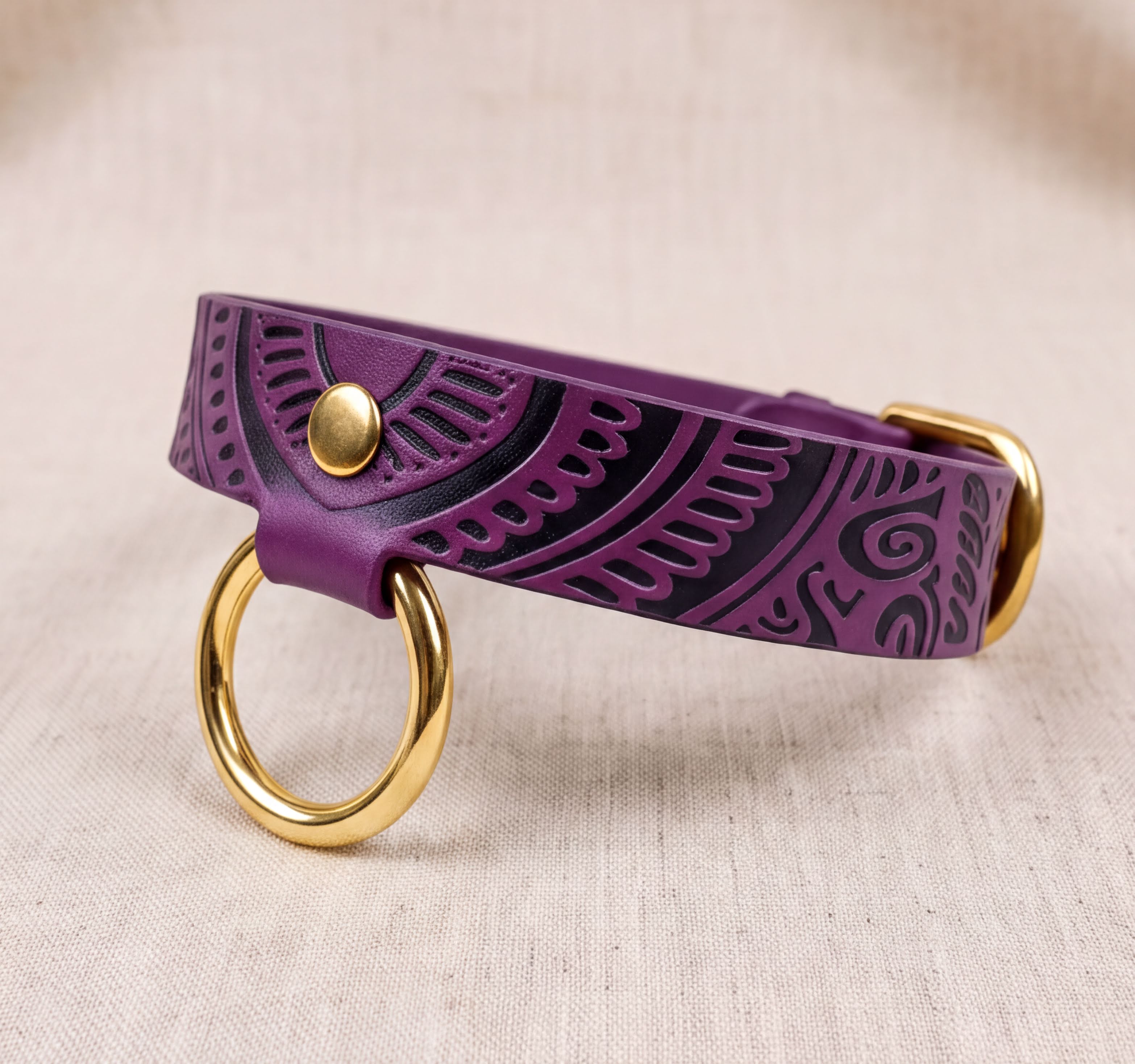 A purple leather dog collar with a gold ring and buckle, placed on a beige background.