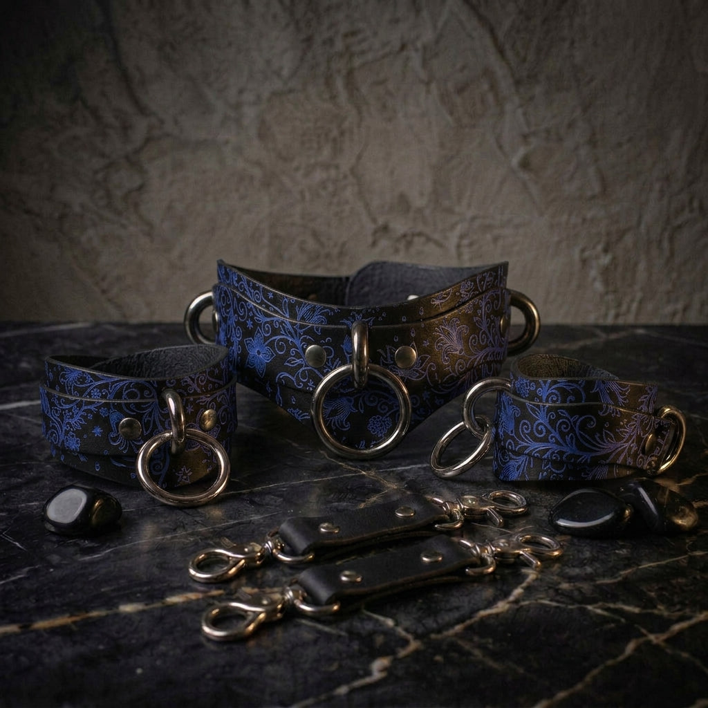 A set of ornate leather straps with metal rings and buckles, arranged on a dark surface.