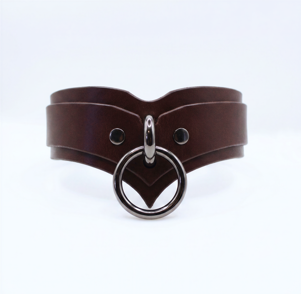A brown leather choker necklace with a metal ring and two circular buttons.