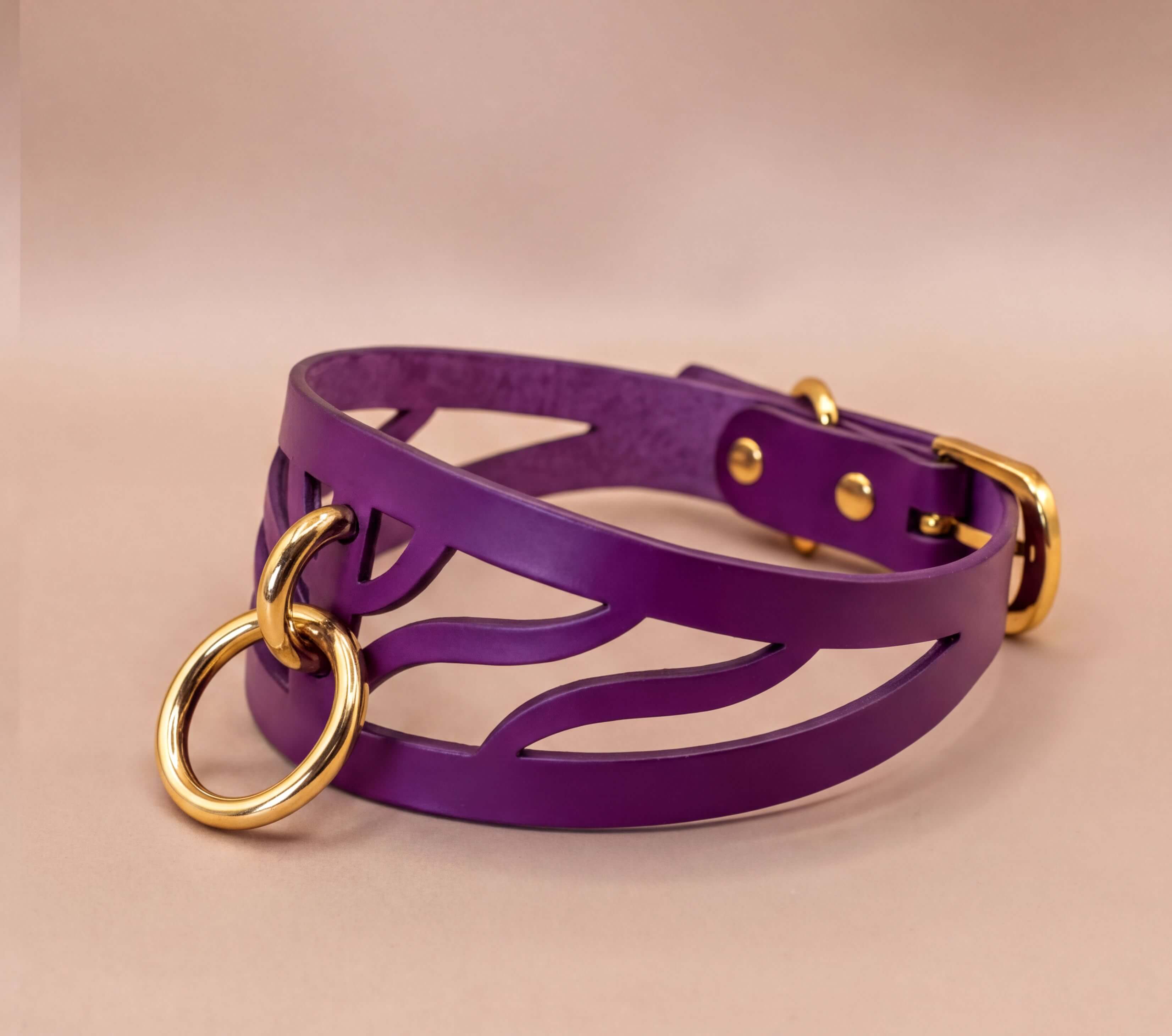 A purple leather choker necklace with a gold-colored metal ring and buckle.