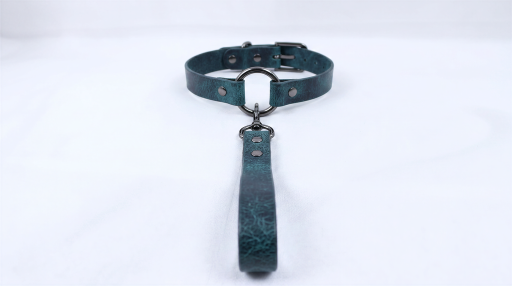 A dark green leather collar with a metal buckle and a handle attached to it.