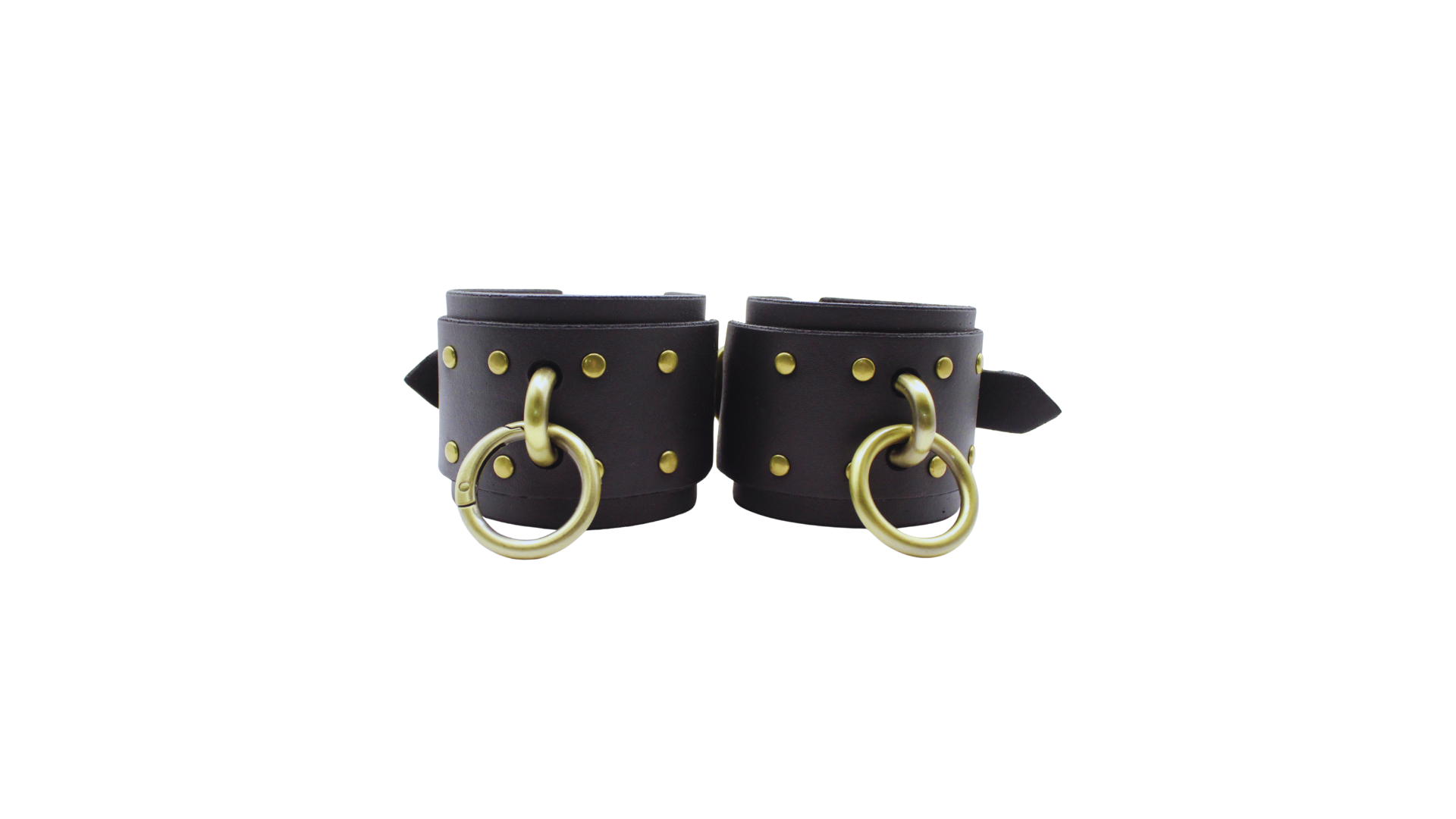 A pair of black leather wrist cuffs with gold-colored metal rings and studs.