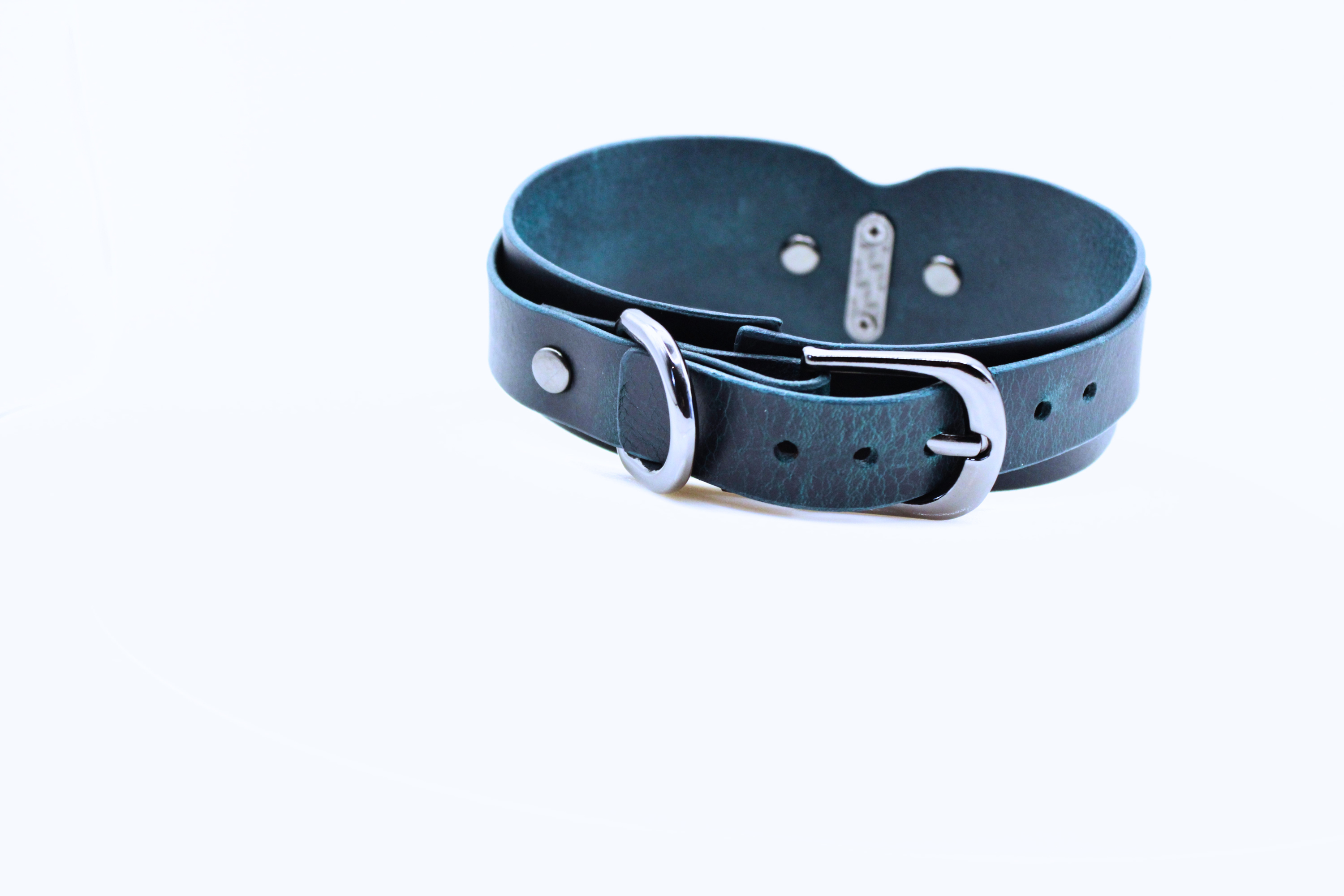 A dark blue leather belt with a silver buckle is shown against a white background.