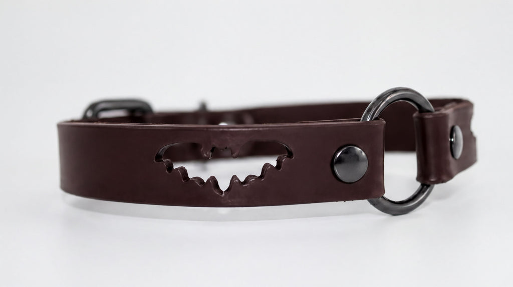 A brown leather collar with a bat cutout design.