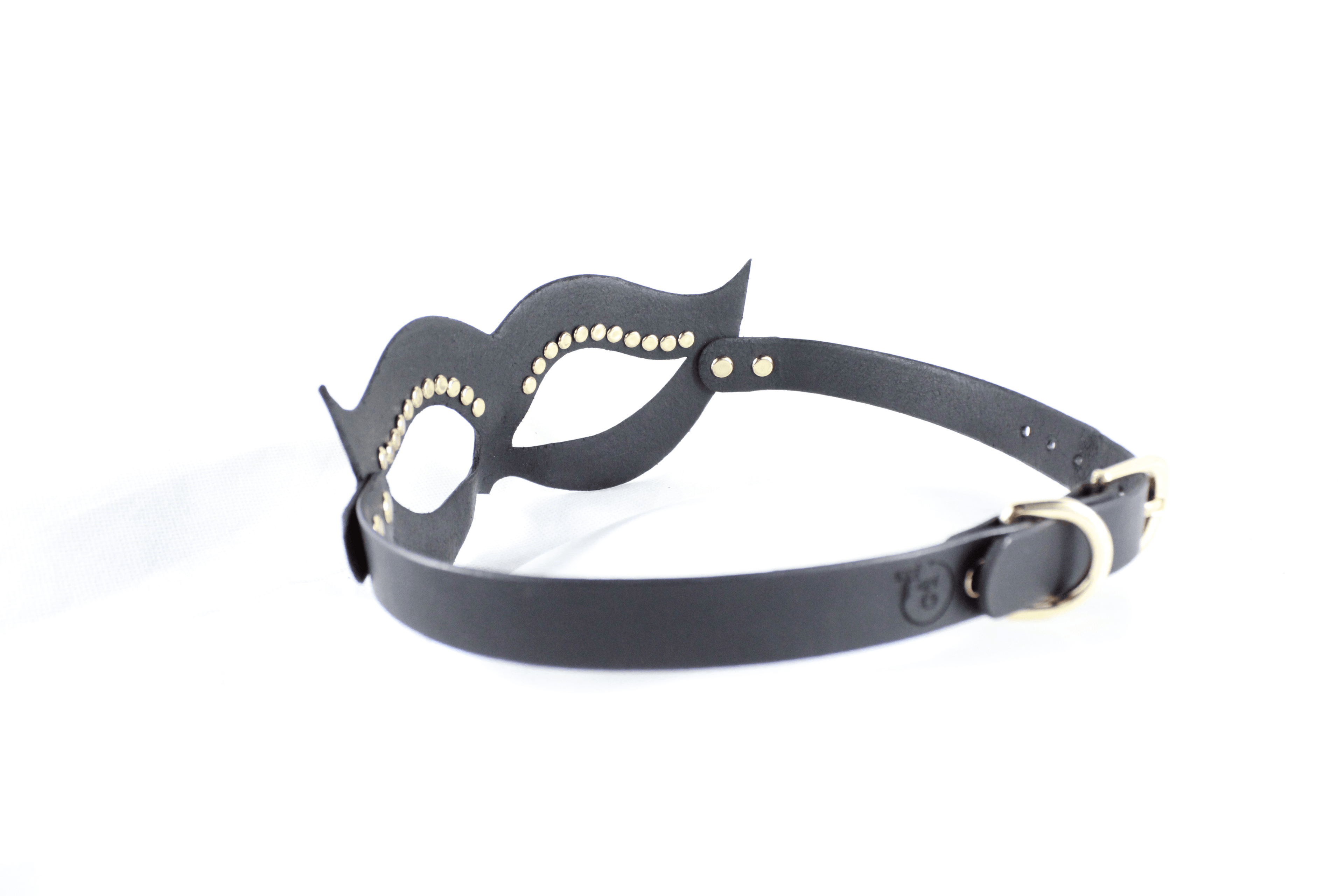 A black leather mask with gold studs on the sides and a black strap with a gold buckle.