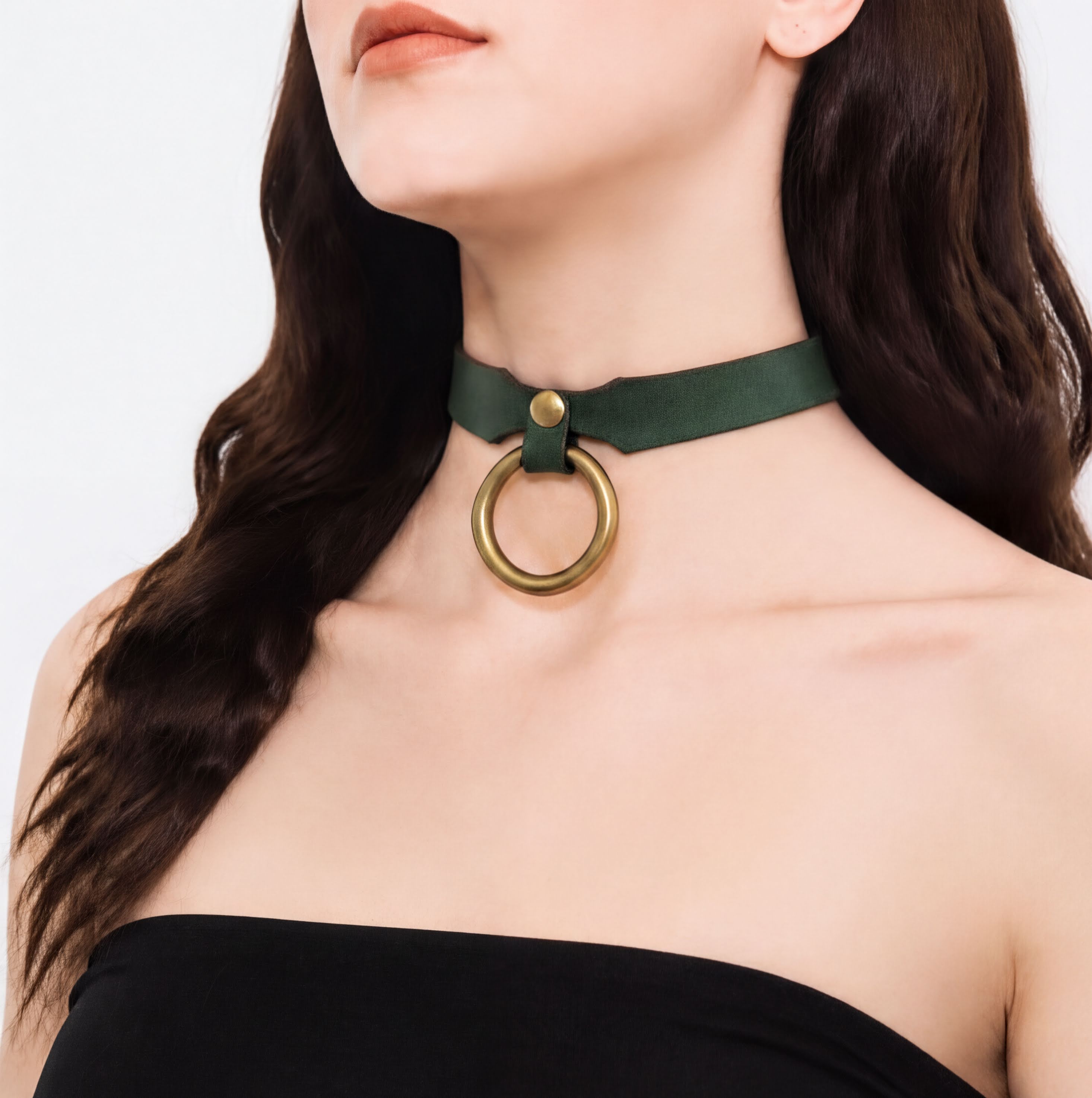 A woman wearing a green choker necklace with a gold ring on it.