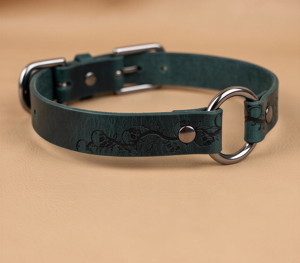 A dark green leather collar with a metal ring and buckle, resting on a beige surface.