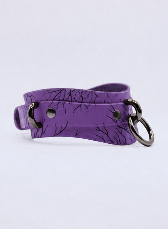 A purple choker necklace with a black tree-like pattern and two metal rings.