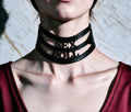 A close-up of a person wearing a black choker necklace with the word "SEX" printed on it.