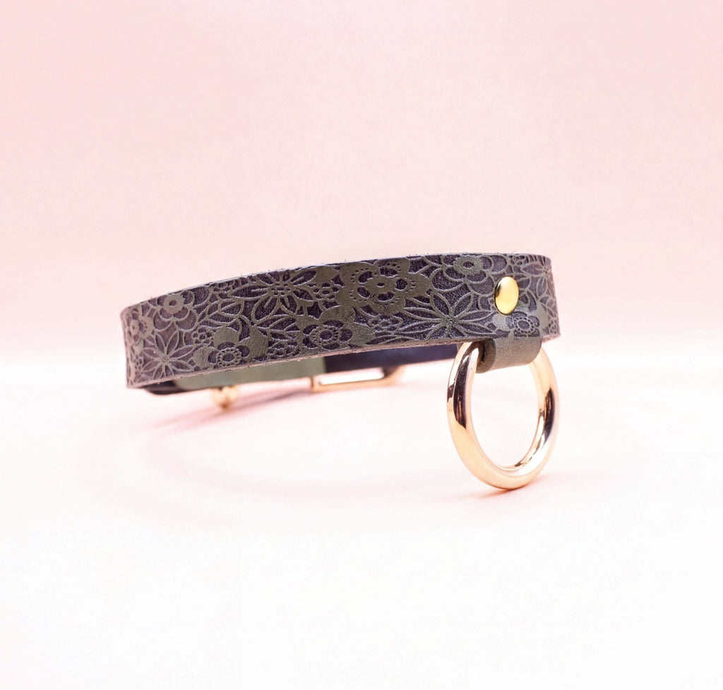 Elegant discreet day collar in premium leather, featuring floral design and metal ring, perfect submissive jewelry accessory.