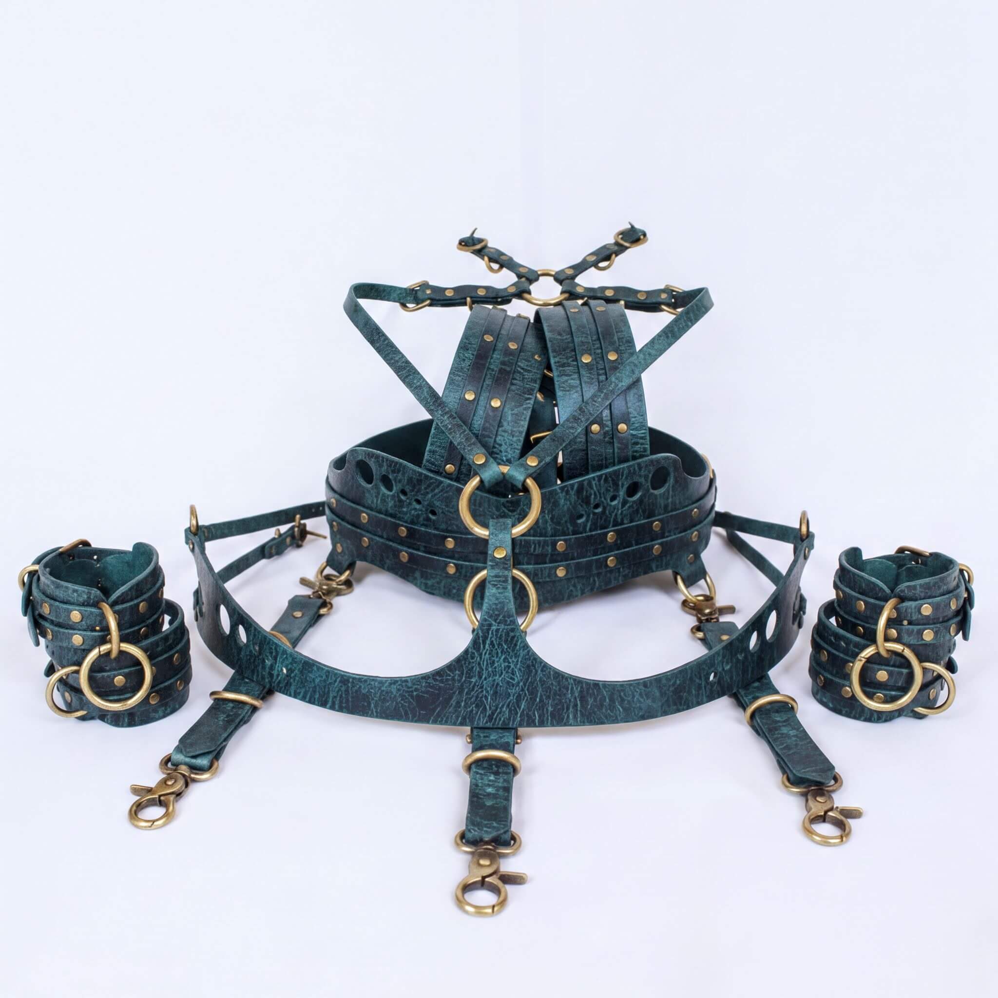A set of dark green leather straps with gold-colored buckles and clasps, arranged in a circular pattern.