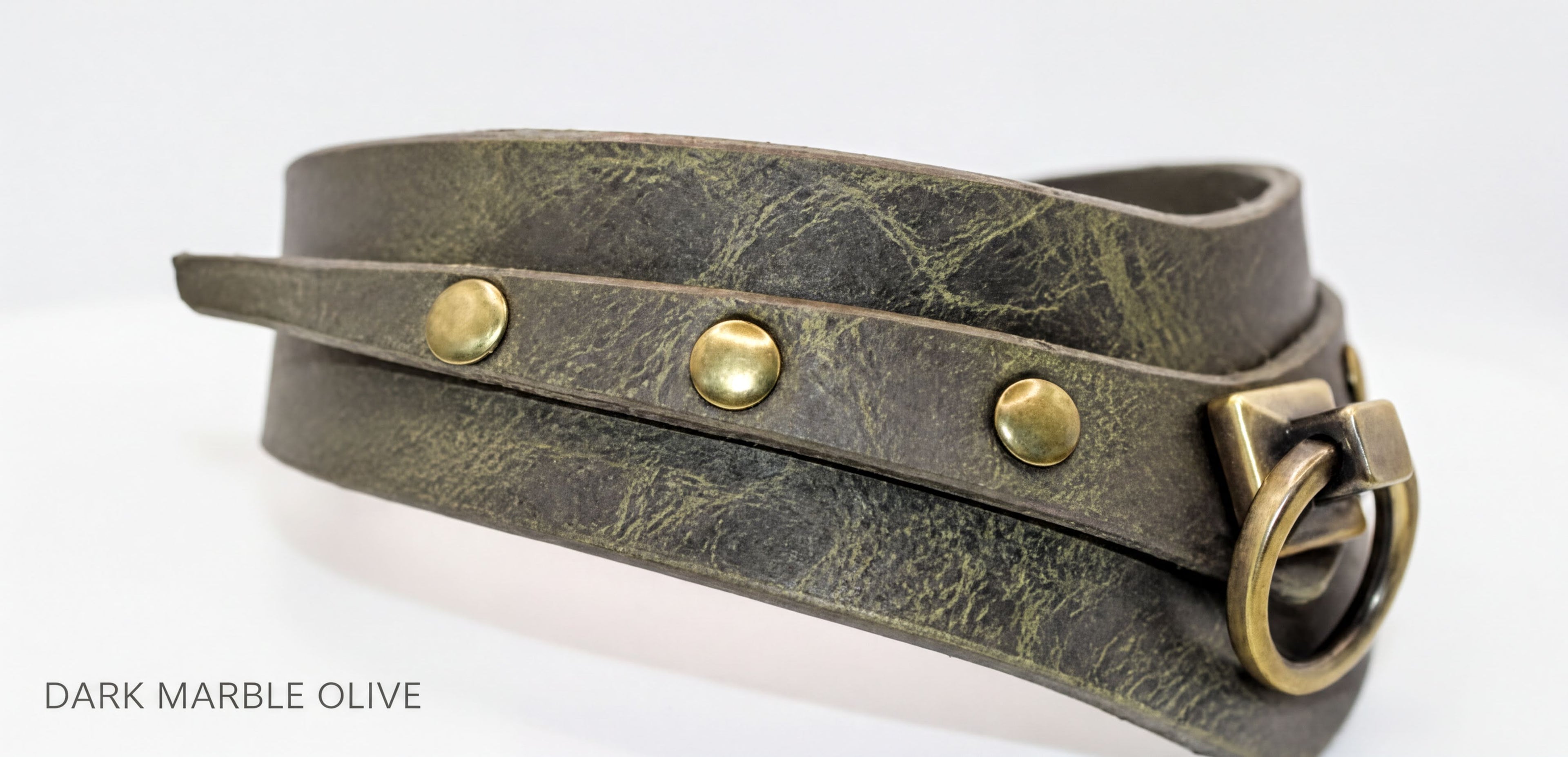 A close-up view of a dark green leather choker necklace with brass hardware, including three round buttons and a ring-like clasp.