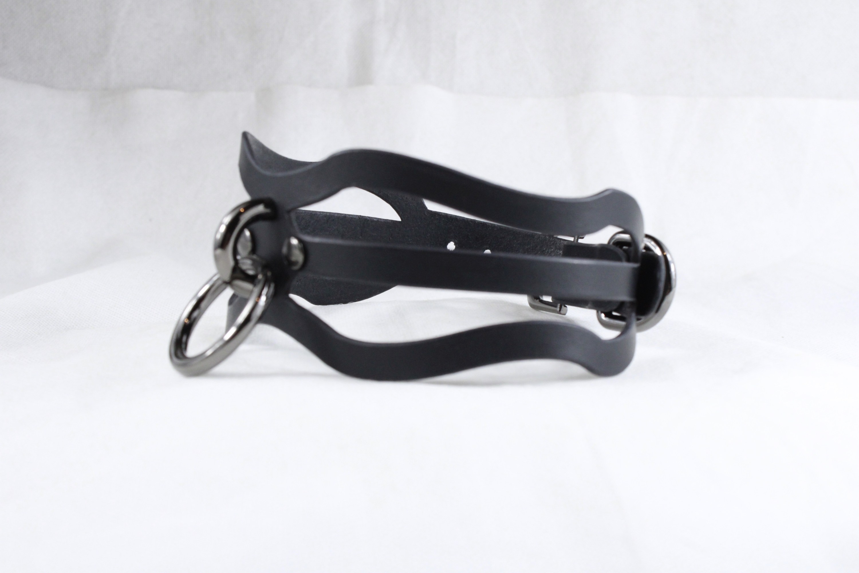 A black leather choker necklace with metal rings and a curved clasp.