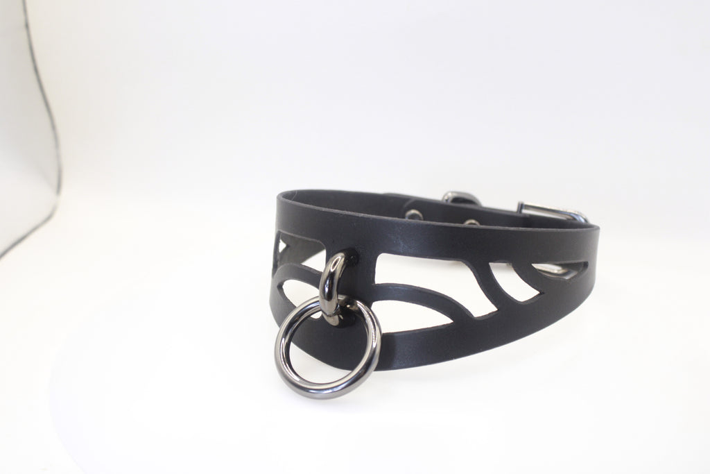 A black leather choker necklace with a metal ring and cutout design.