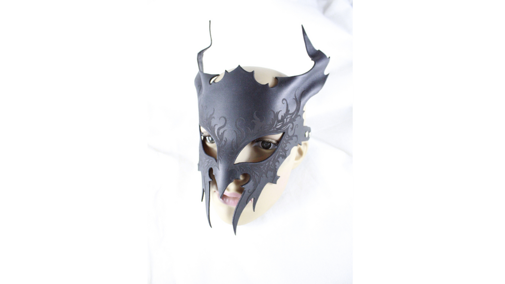 A black mask with horns and an intricate design, resembling a dragon or other mythical creature.
