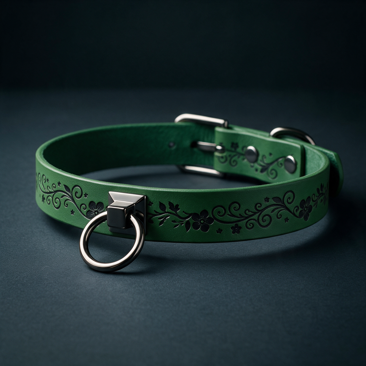 A green leather collar with a metal ring and decorative floral patterns on the band.
