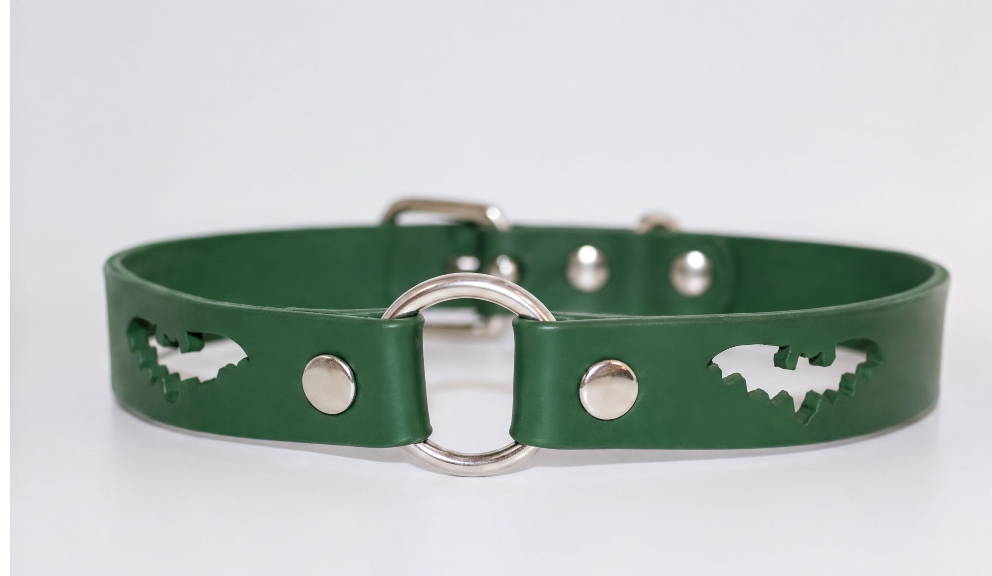 A green leather dog collar with a silver metal ring and cutout designs.