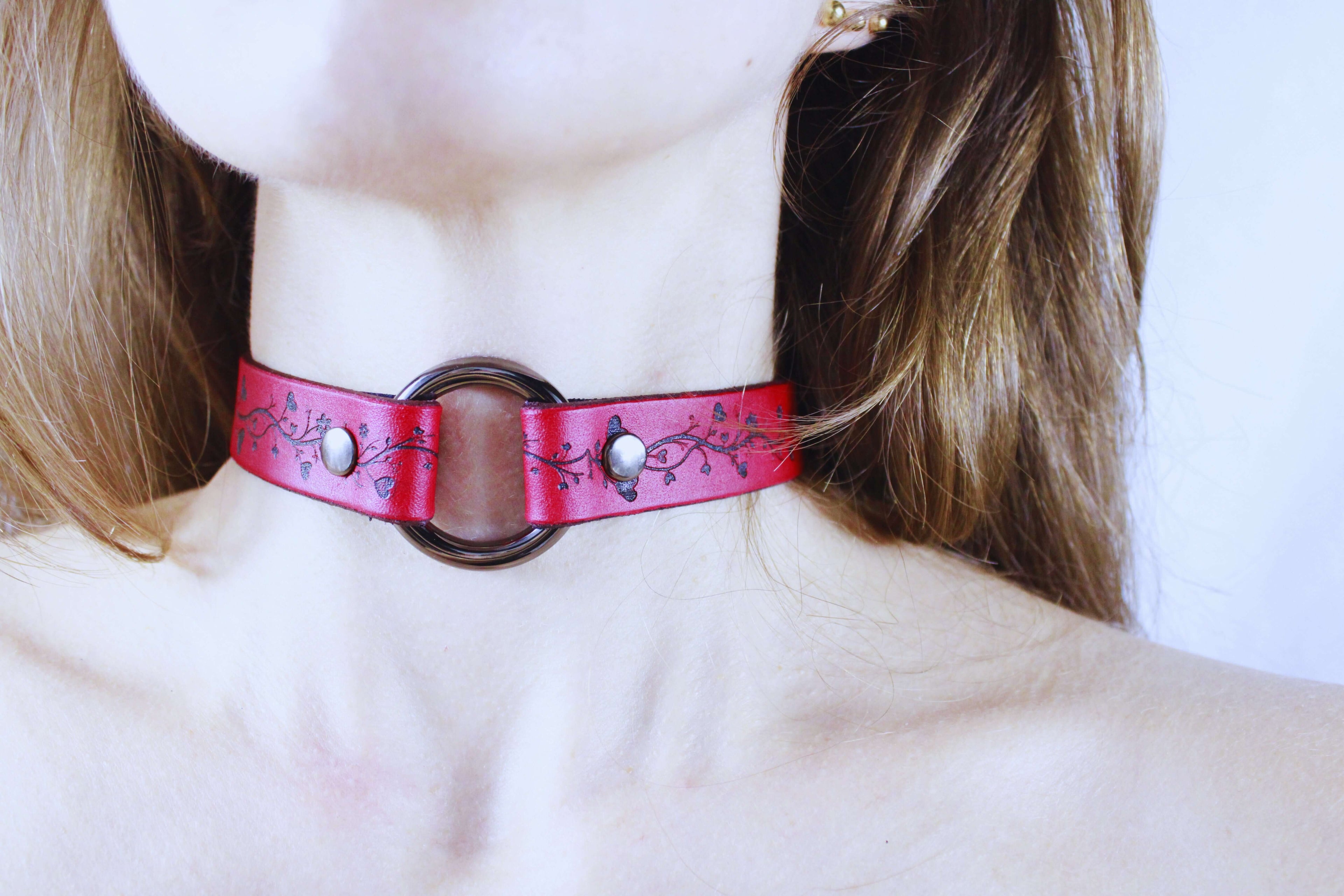 Vine Pattern Submissive Collar displayed on a model, showcasing elegant red leather and vine motifs.