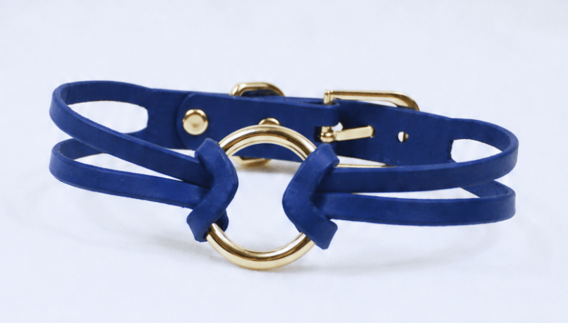 A blue leather choker necklace with a gold-colored buckle.