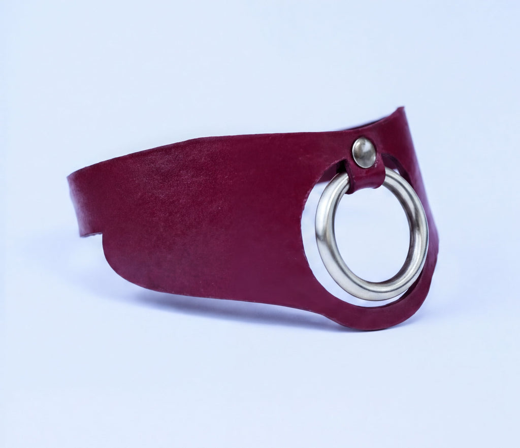 A red leather choker necklace with a silver metal ring on the front.