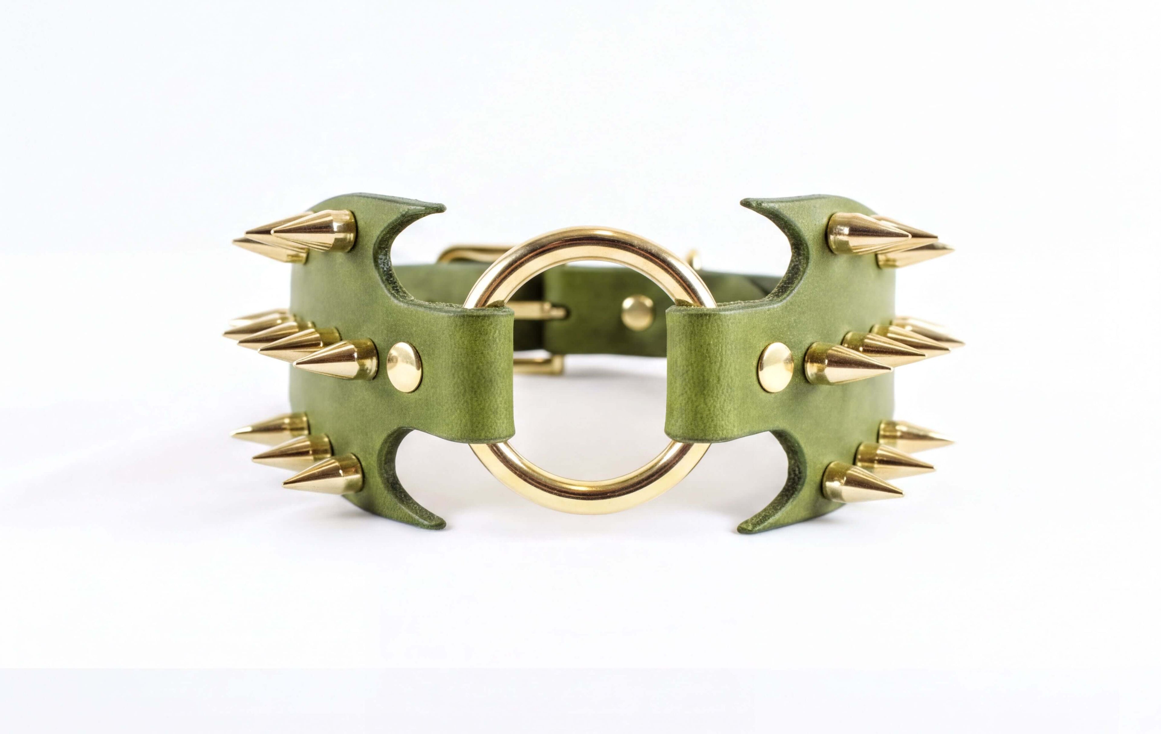 A green leather choker necklace with gold spikes protruding from it.
