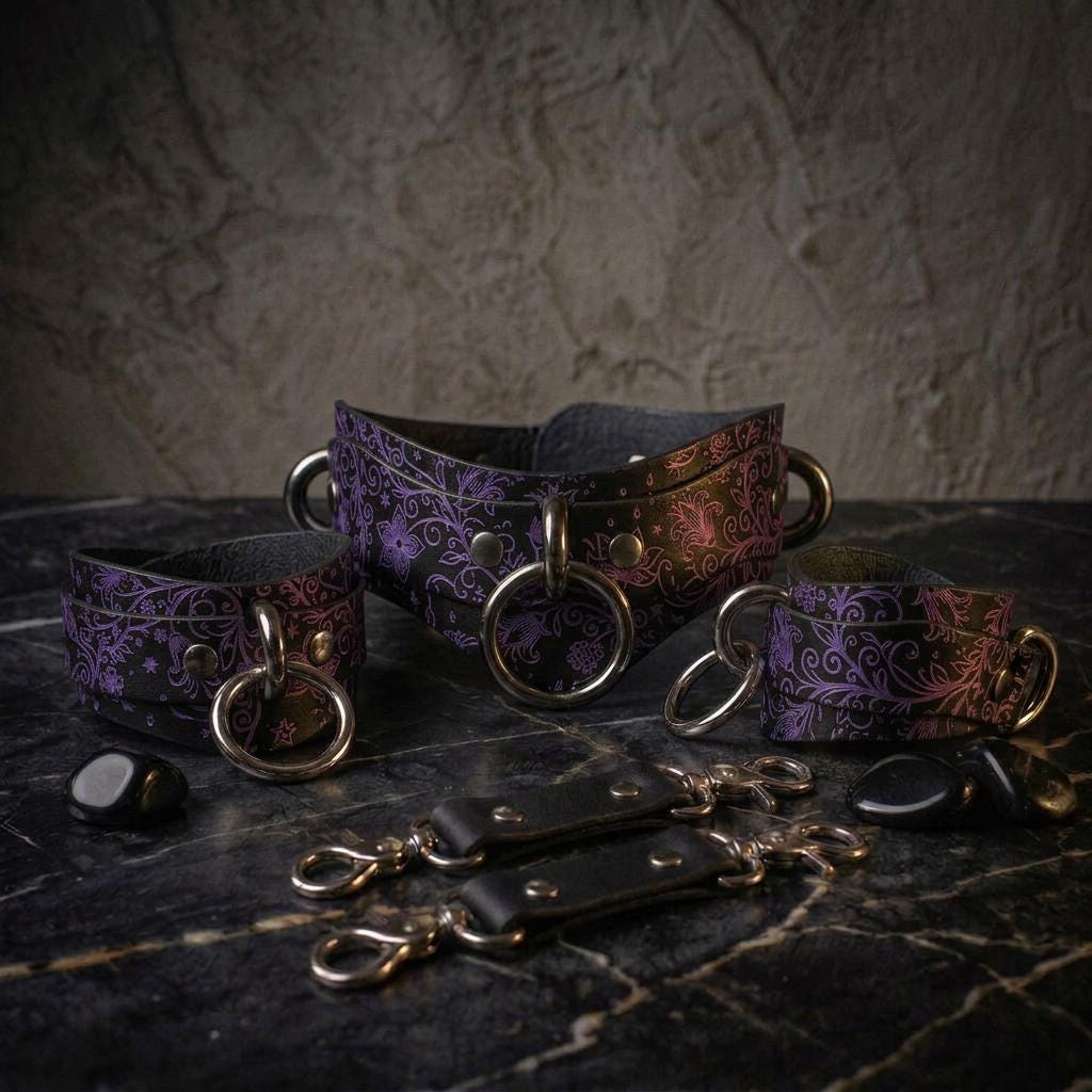 A set of purple leather choker necklaces and straps with metal rings and buckles, arranged on a dark surface.