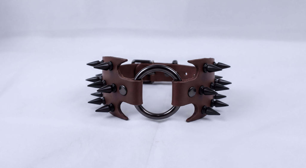 A brown leather choker necklace with spikes protruding from it.