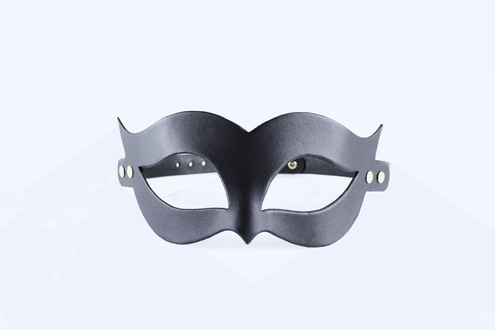 A black mask with a unique, cat-like design is shown against a white background.