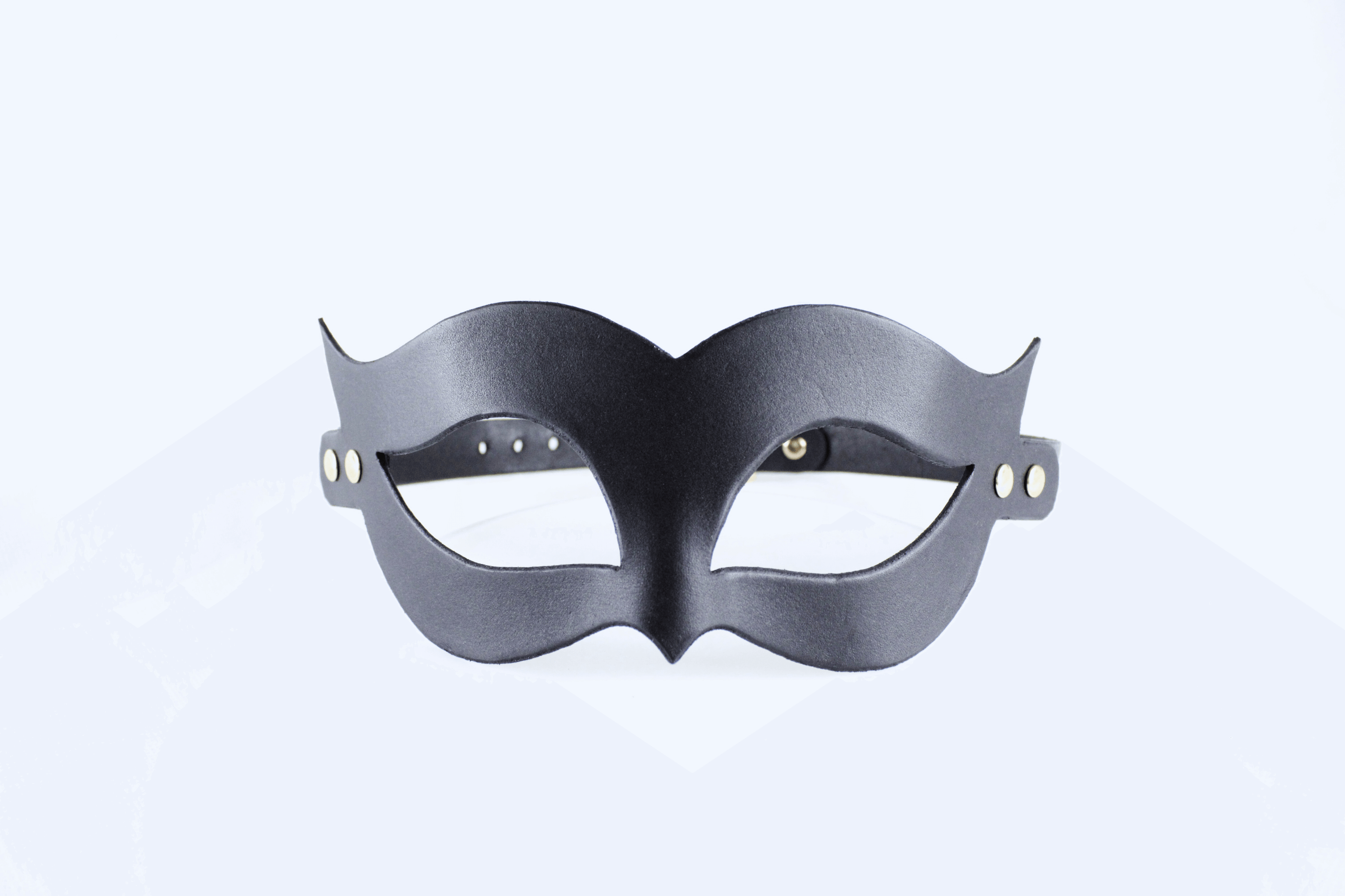 A black mask with a unique, cat-like design is shown against a white background.