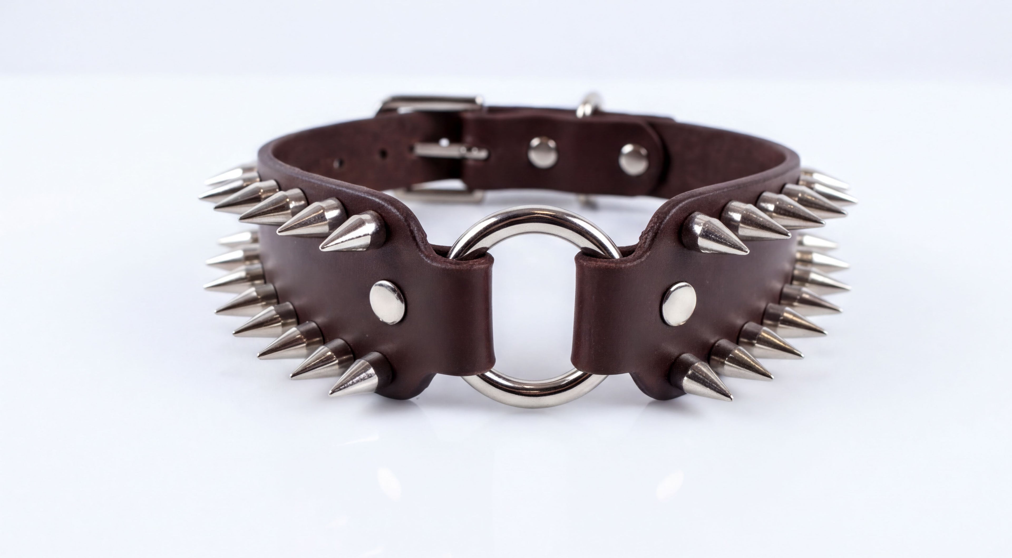 A close-up image of a leather choker necklace with spikes protruding from it.