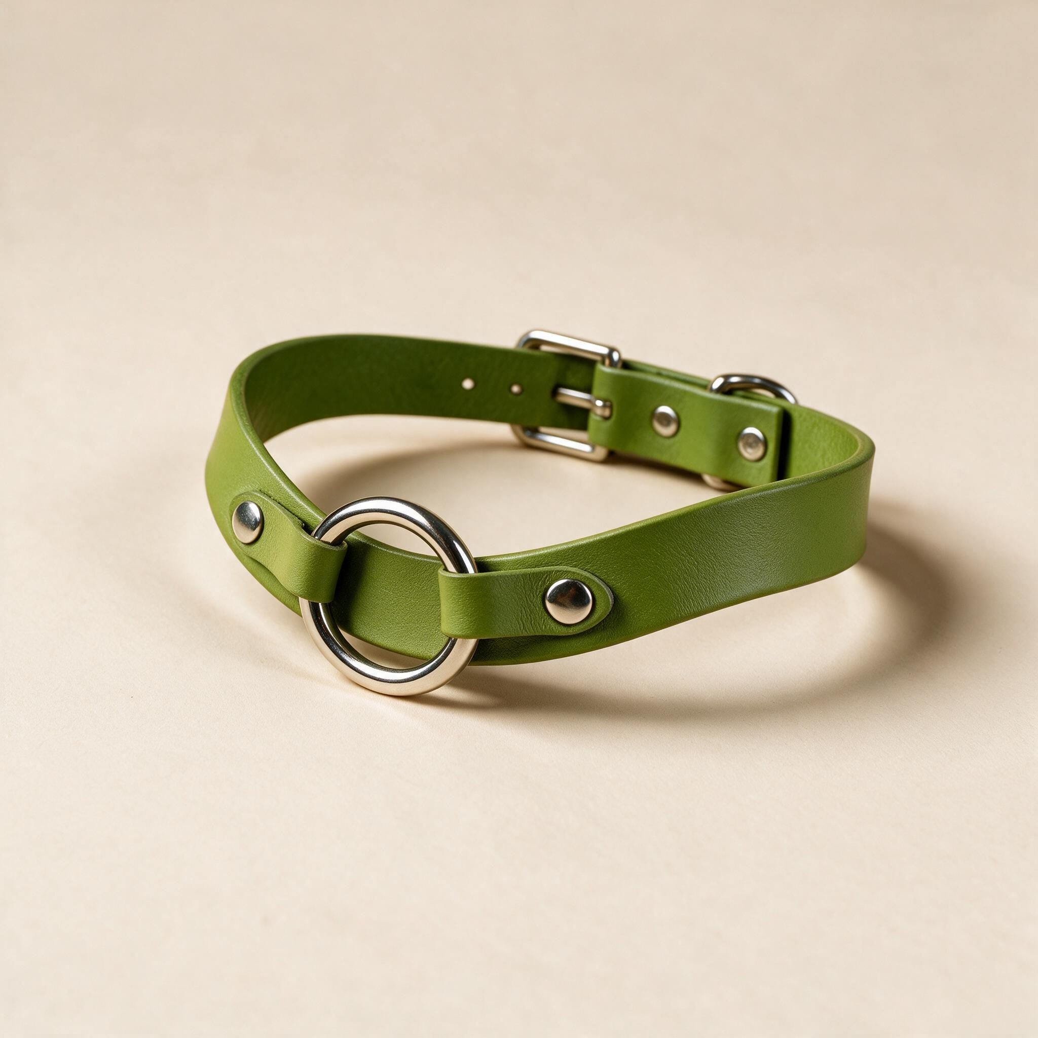 A green leather choker necklace with a silver metal ring and buckle.