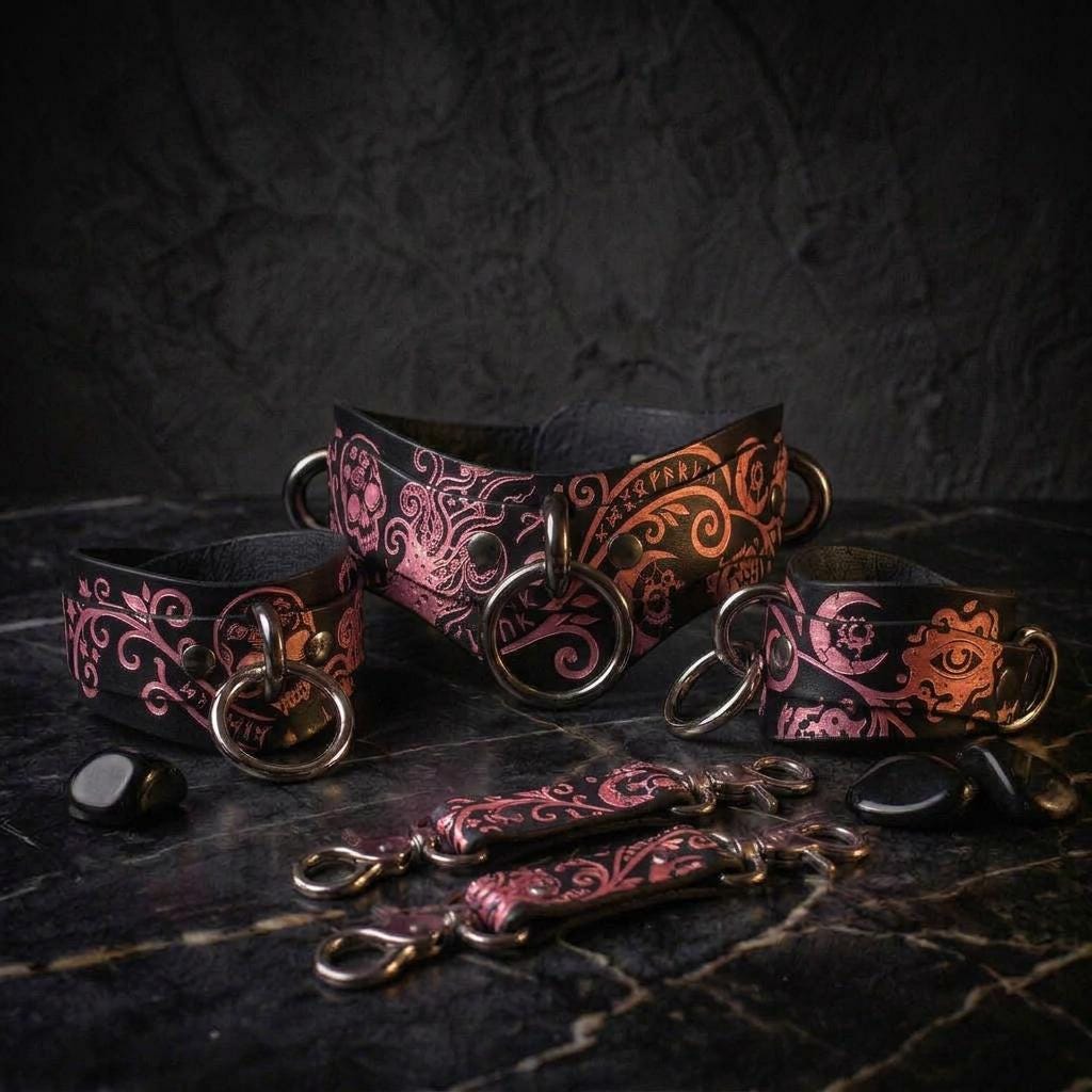 a collection of ornate leather straps and charms, including a large black leather strap with a floral pattern and several smaller straps with similar designs.