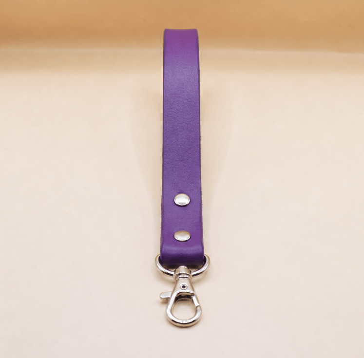 A purple leather strap with a metal clasp and hook attached to it.