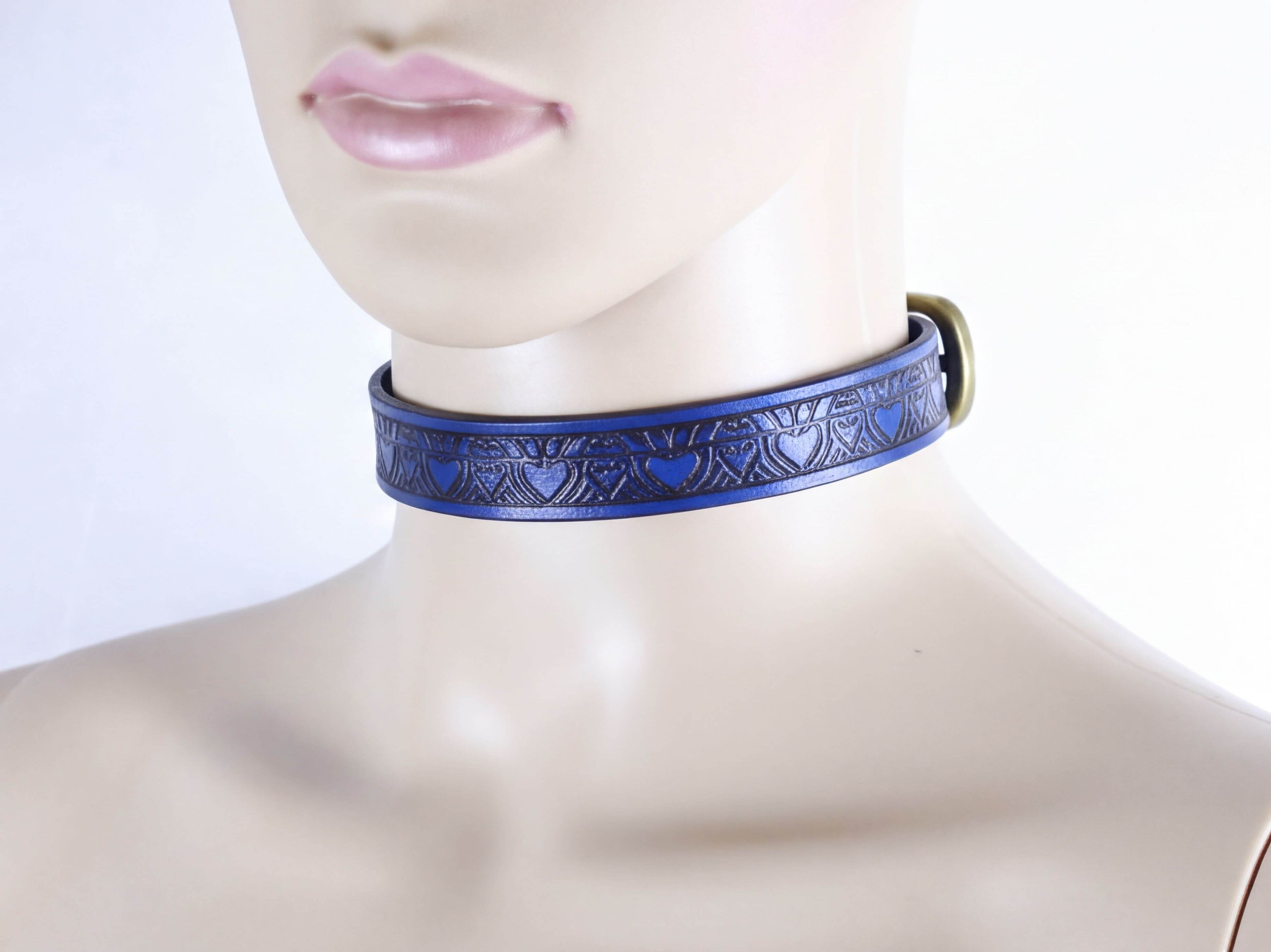 A mannequin wearing a blue choker necklace with a heart pattern.